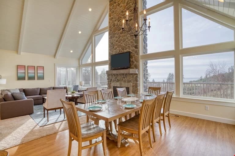 Netarts dining room with a set table, river-rock fireplace, and windows to the ocean