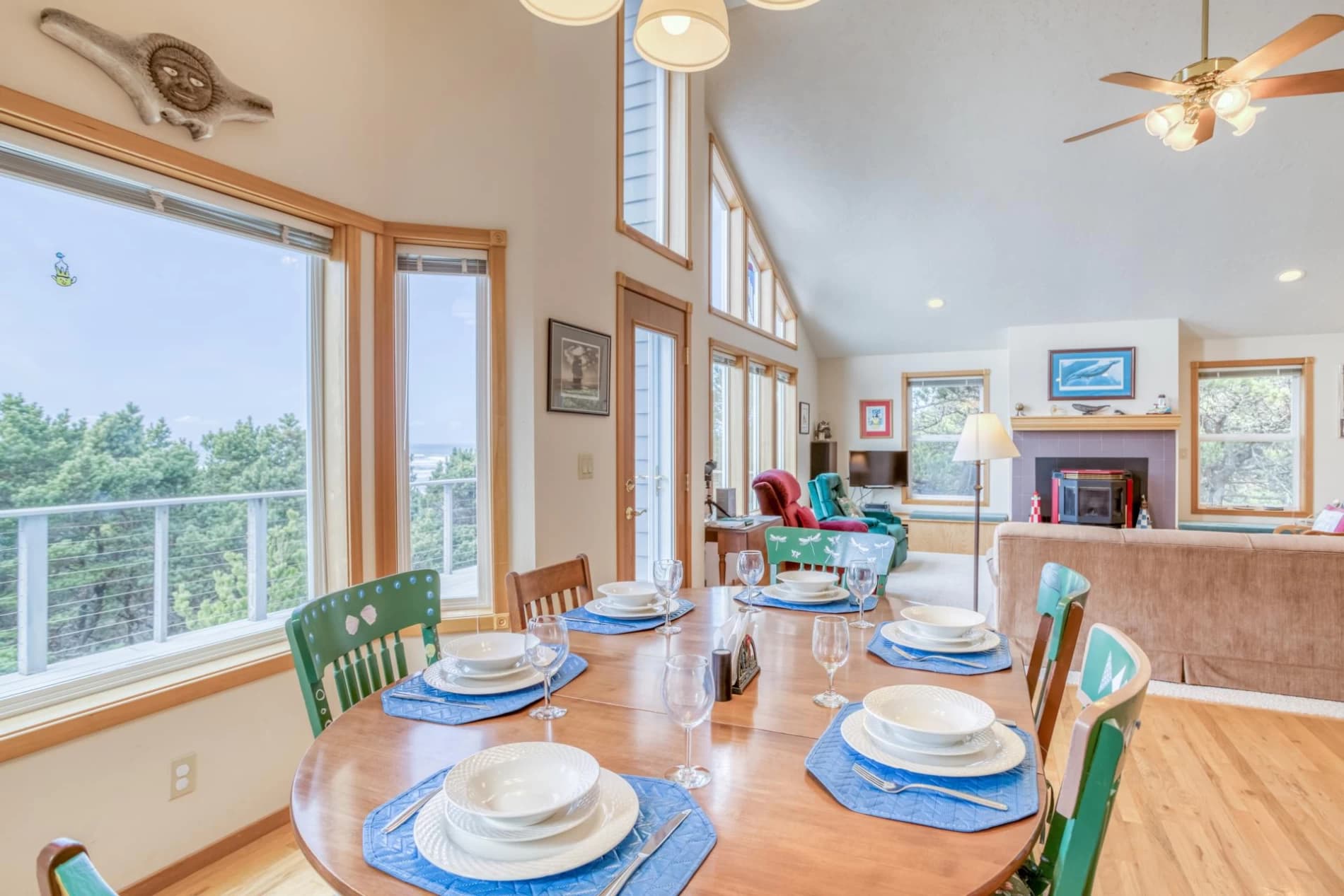 Dining room in Seal Rock with an oval wood table, green chairs, and vaulted living space