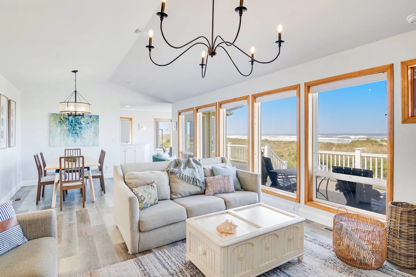 Vaulted living room with a sofa, chandelier, and ocean windows in Waldport
