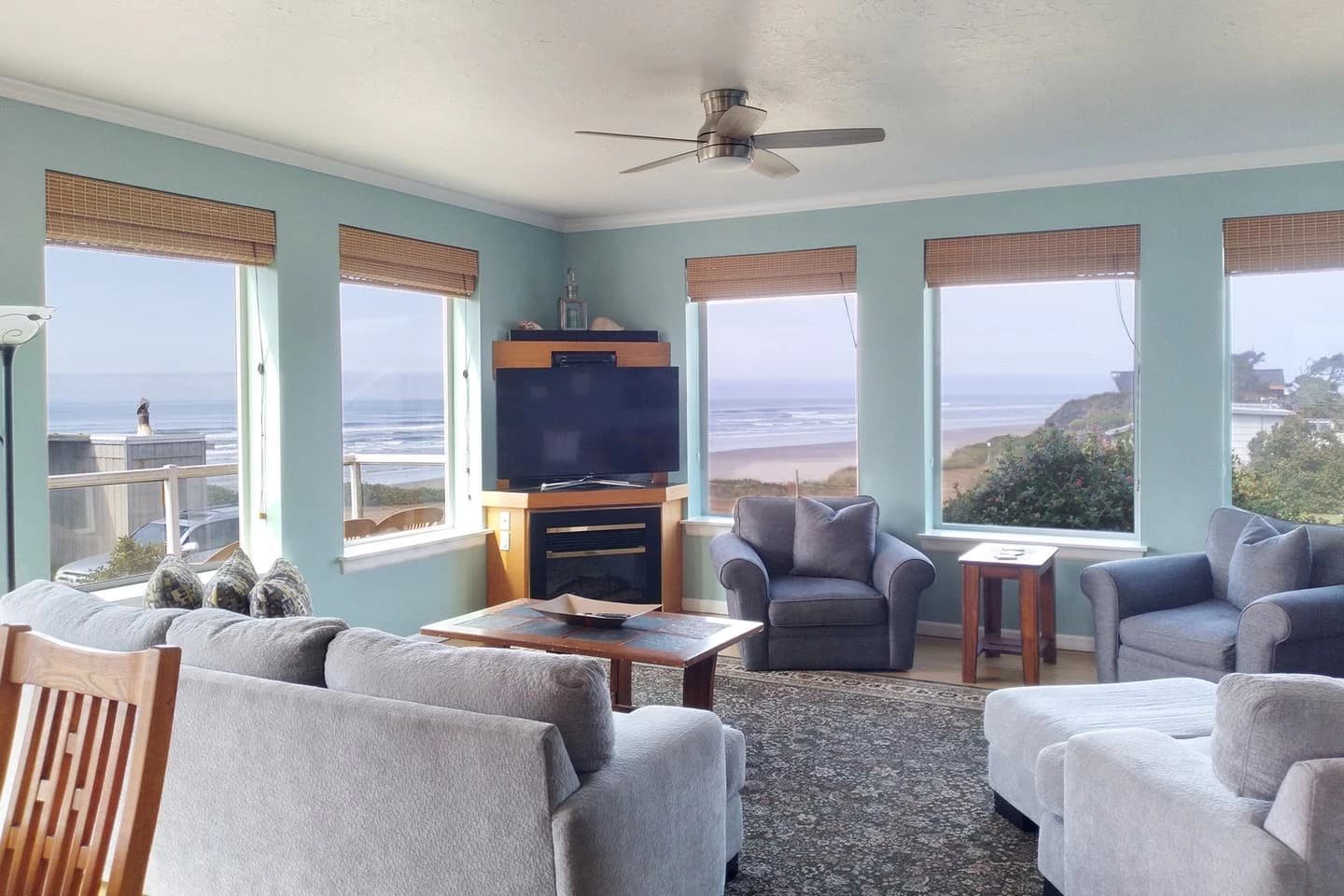 Pale-blue living room in Yachats with grey sofas and ocean views through large windows