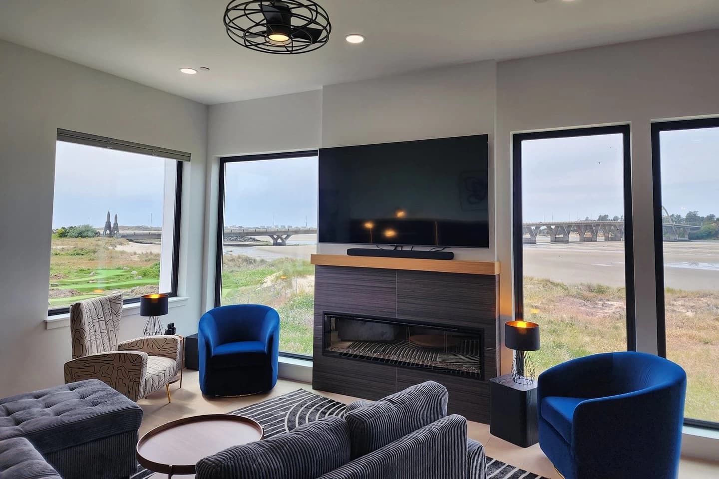 Waldport living room with blue chairs, a fireplace, and windows to the bay bridge