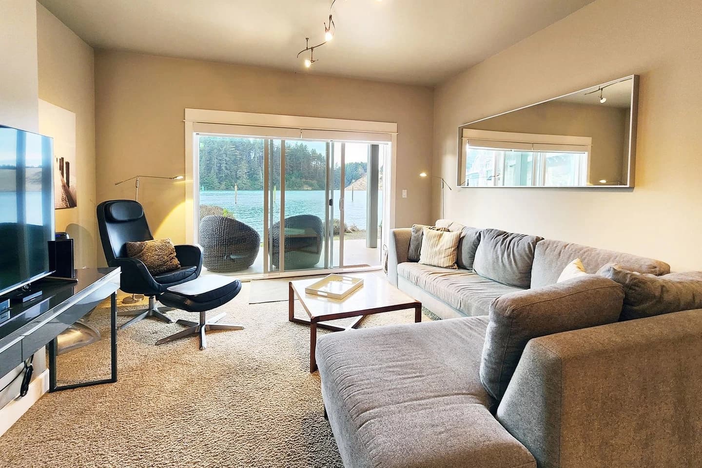 Florence living room with a gray sofa, black recliner, and deck over the water