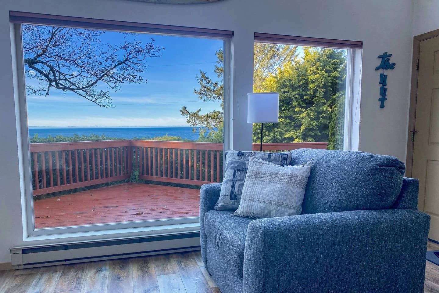 Yachats living room with a blue armchair and windows onto a deck and the ocean