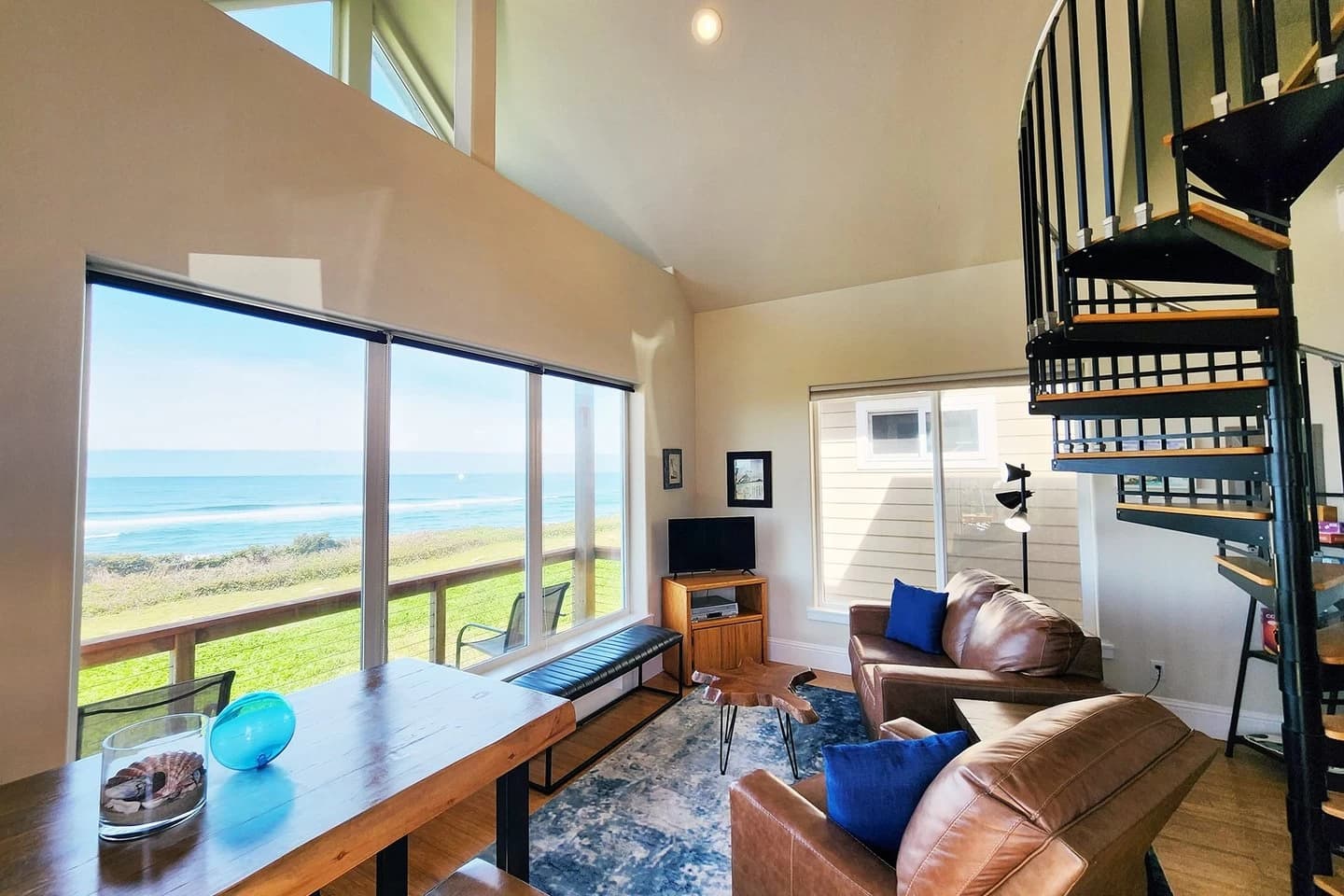 Yachats living room with leather seating, a spiral stair, and ocean-view windows