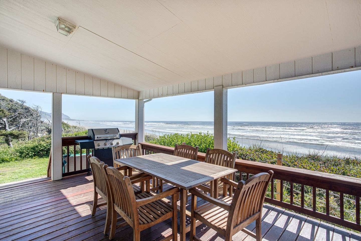 Oceanfront single-story beach house on a bluff with covered porch, hot tub, and stunning views of the sandy Oregon Coast.