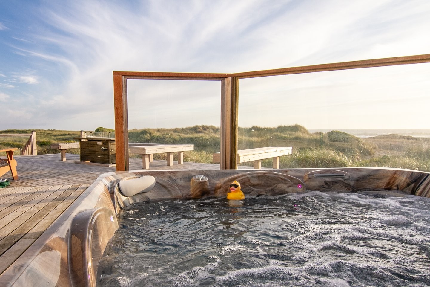 Beachfront deck with a glass wind break and a floating ducky..