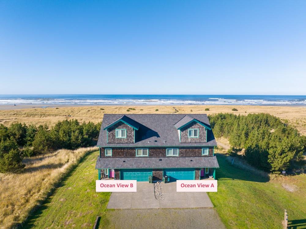 Large three-level adjoining townhouses on a grassy area with 3 decks.