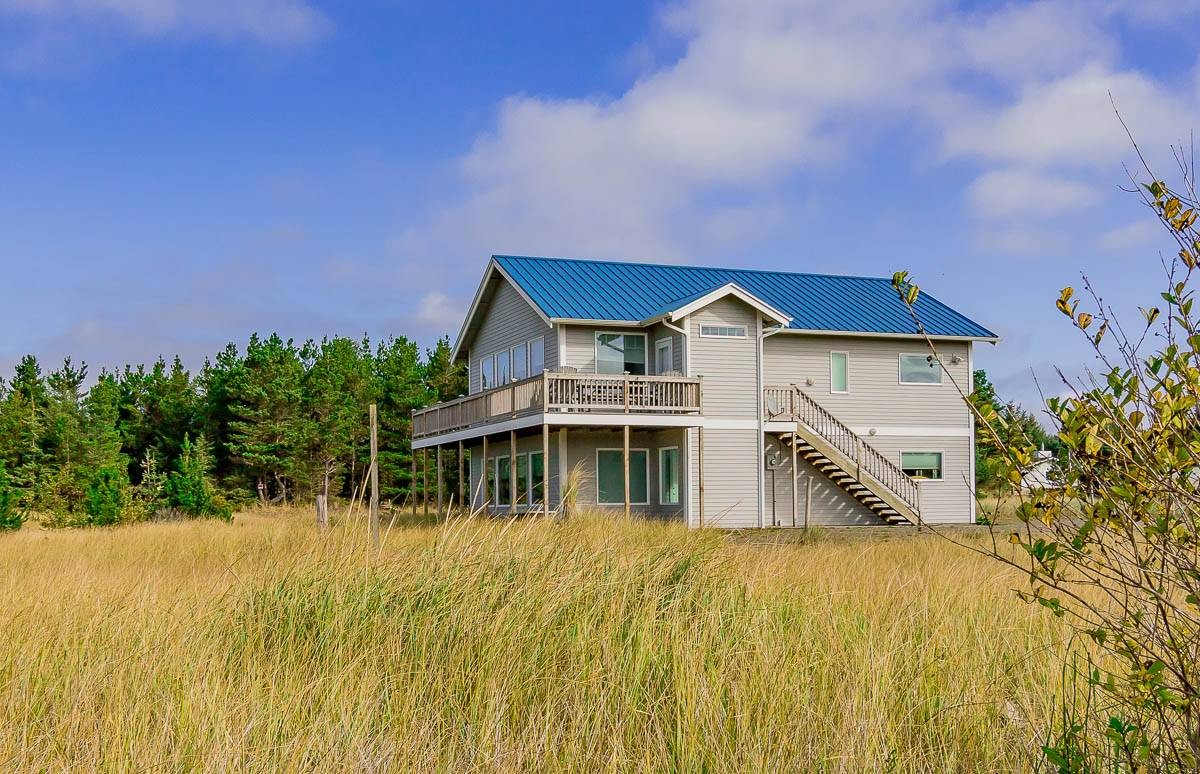 Oceanfront deck views with chairs and flat grassy dunes